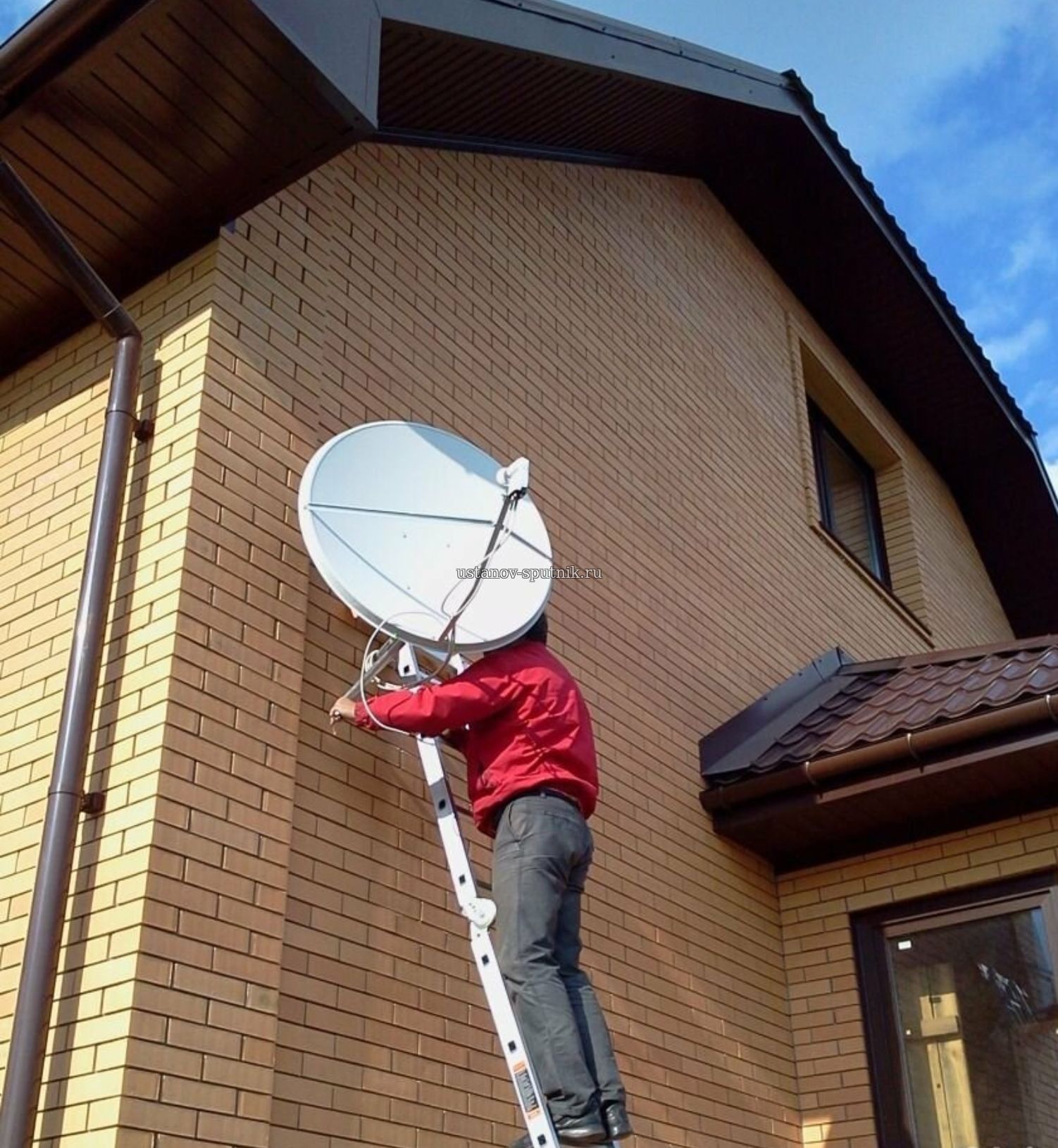Установка спутниковой антенны Телекарта в частном загородном доме, мастер стоит на лестнице и настраивает спутниковую антенну, Голубой залив, новосибирская область 